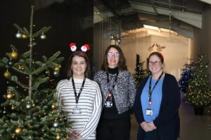 Staff next to Christmas Trees