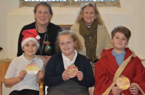 Stanton Primary School and Nursery at the church that they have helped decorate in time for Christmas - with their teacher Mrs Smith and The Reverend Cathy Bladen