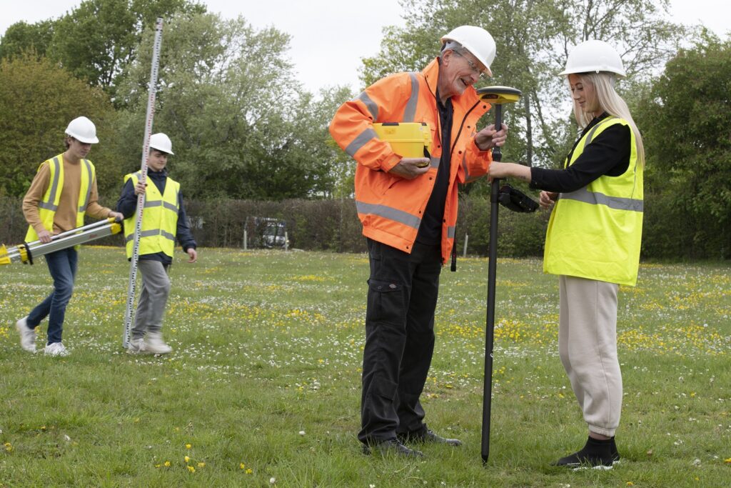 Tutor showing construction students how to do field surveys
