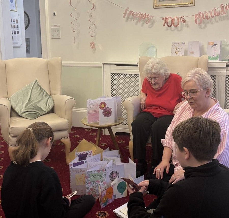 Nelly with students from Sunrise Academy reading out birthday cards to Nelly that they had made for her - photo by Lound Hall