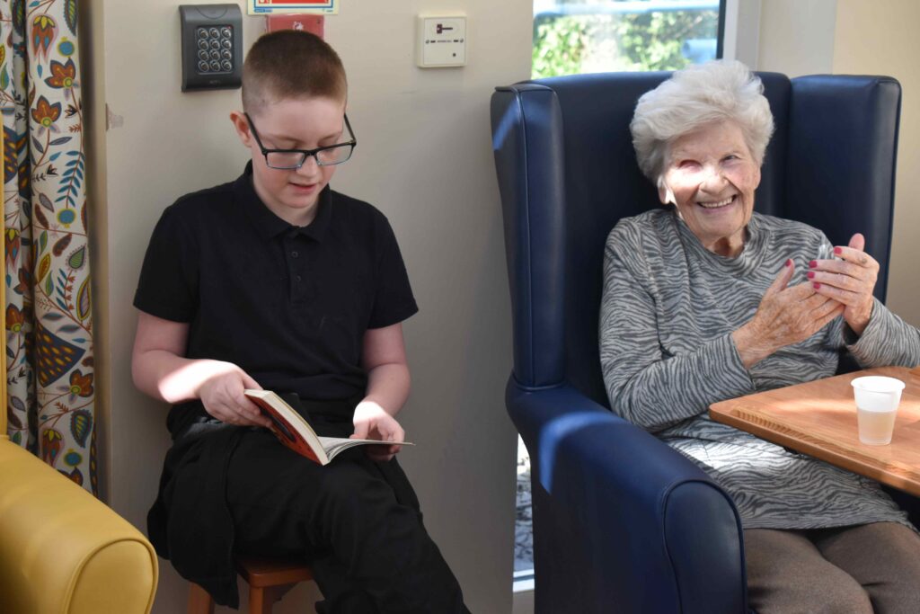 Jacob from Duke of Lancaster reading a story to a Woodspring House resident on World Book Day