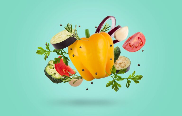 Set of raw organic vegetables and greens over blue background, fresh ingredients for healthy food flying in the air, panorama. Summer diet, nutrition, vitamins and minerals in food concept