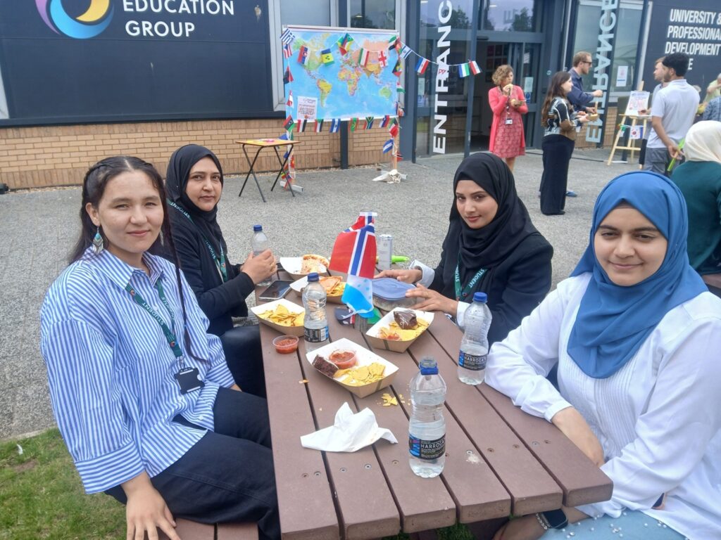 People smiling as they eat food at the refugee picnic